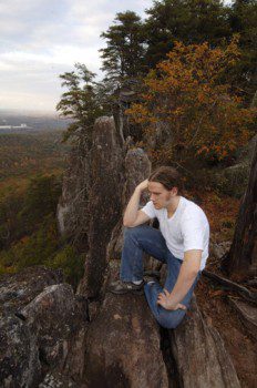 A young man enjoys the view after climbing Kings Pinnacle Trail in Crowders Mountain State Park.