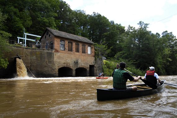 Paddlers on the South Fork River look at a small, independent hydro power generating plant on the river.