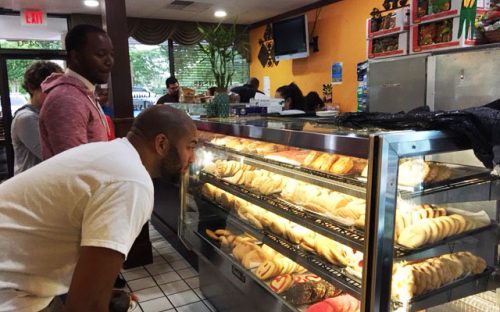 Participants look over the bakery case at the Salvadoreña restaurant during a May 6 tour organized by residents of the nearby Grove Park neighborhood. Photo: Ashley Clark