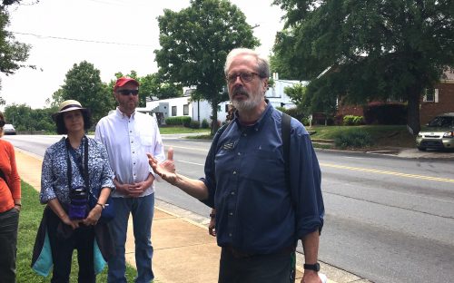 Walk leader Tom Hanchett, on a May 13 walk, describes the historic Excelsior Club behind him on Beatties Ford Road, a nightclub that opened in 1944 and hosted entertainers Nat King Cole and Louis Armstrong. as well as hundreds of community events. Photo: Mary Newsom 