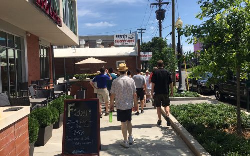 City Walk participants see new construction and the newly opened Fidelli Kitchen,  left, cheek-by-jowl with the venerable Price's Chicken Coop on Camden Road. Photo: Mary Newsom 