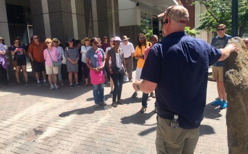Walk leader Scott Syfert, standing at a marker along South Tryon Street, describes the role of the Catawba Indians in the region's history. Syfert led a walk about Charlotte history on May 20. Photo: Mary Newsom