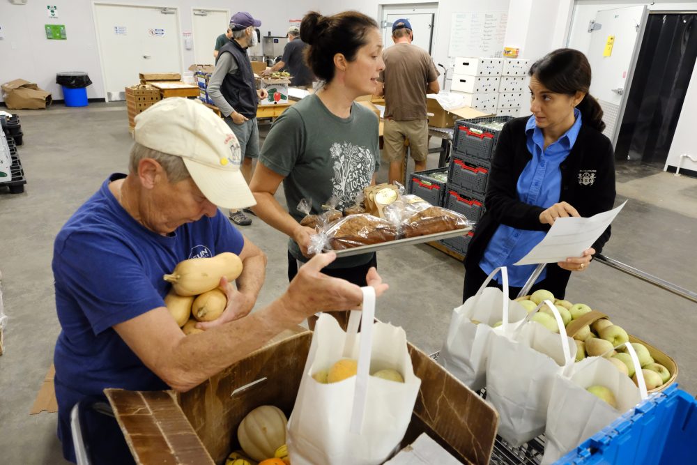 From left: Volunteer Beth Whitman packs produce boxes, Mandy Davis, co-director of Sandhills Farm-to-Table, and Mireia Brunner, owner of Aberdeen Bakehouse. Sandhills Farm-to-Table subscribers can order bread and pastry from Mireia's shop online for delivery. Photo: Nancy Pierce