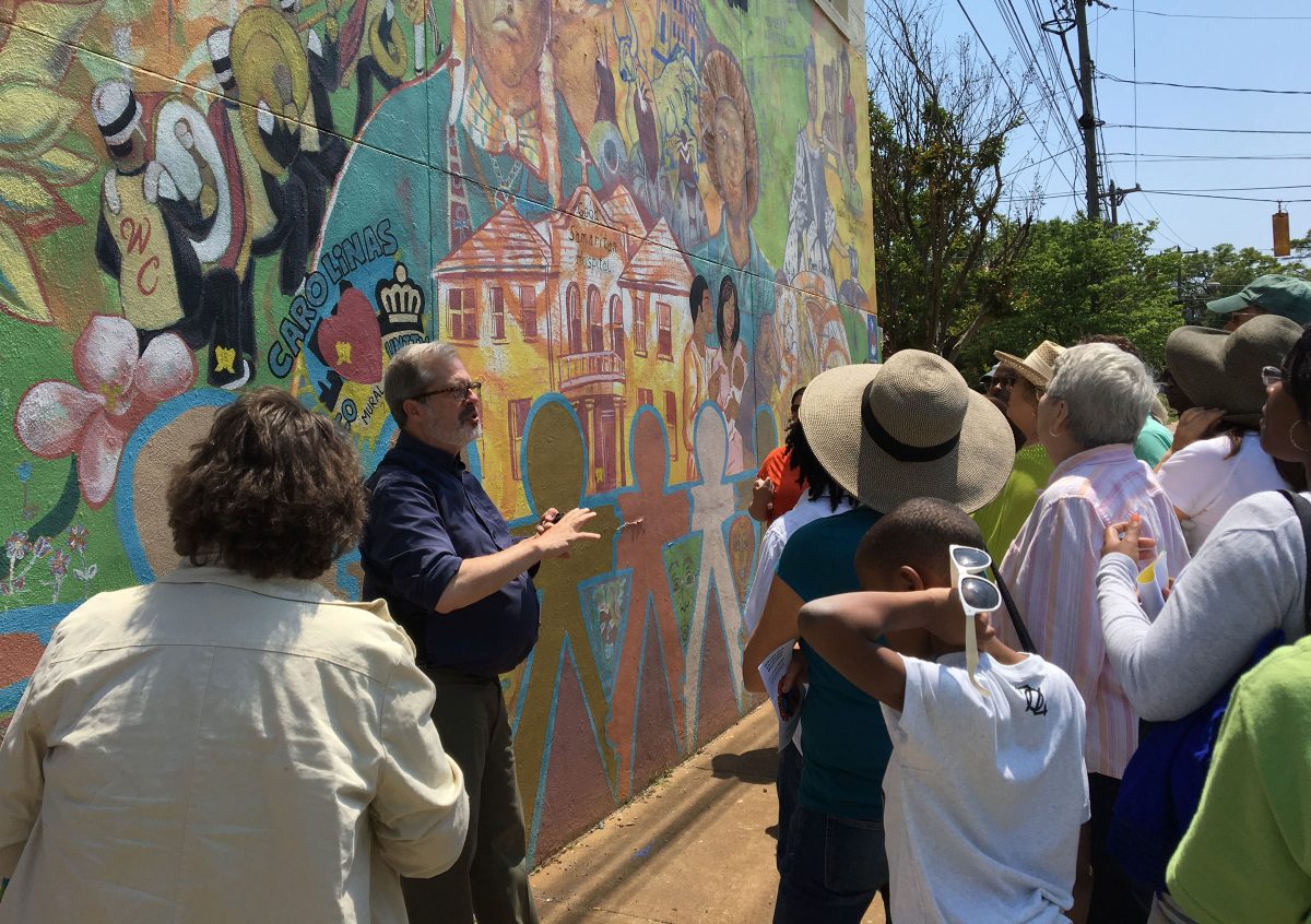 Local historian Tom Hanchett discusses a mural with participants in a 2018 Charlotte City Walk. 