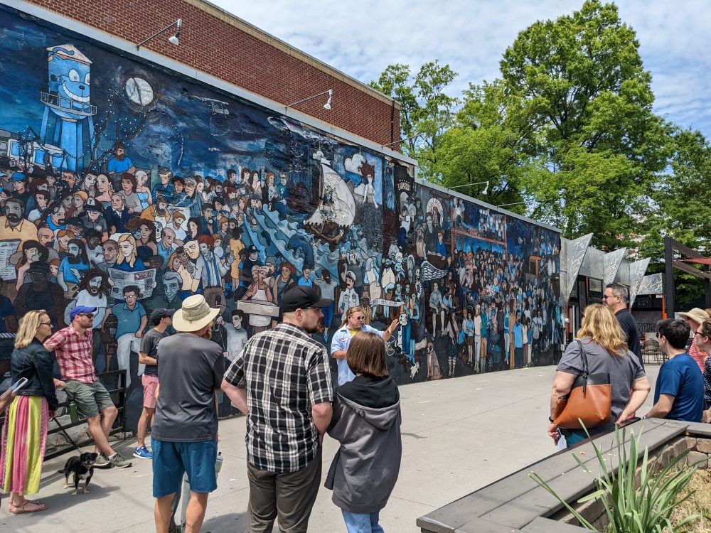 People standing by a mural