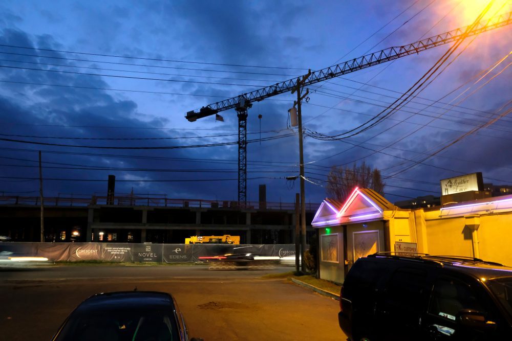 Neon lights from the decades-old South Boulevard adult entertainment venue, Leather and Lace, illuminate the parking lot of beloved burger and ice cream shop, Mr K.s, which dates to 1967. In the background, a short walk from the East-West Boulevard Station, Crescent Communities' Novel Atherton "luxury apartment homes" is set to open in 2019. Photo: Nancy Pierce  