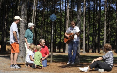A family enjoys a concert by a guitar player beside the Oakboro city trail on a cool day in October 2010.