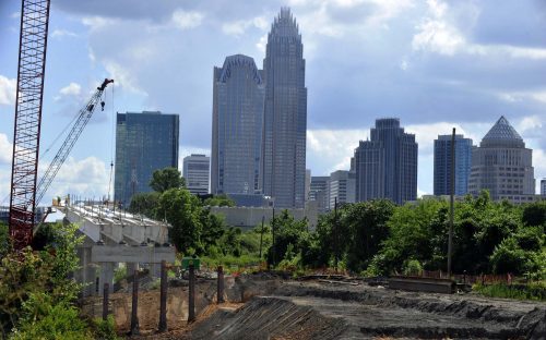 The uptown Charlotte skyline, seen from the Blue Line Extension bridge over the CSX freight line at East 16th Street. The crane lifts in wooden forms, to form concrete for the bridge overhang. Photo: Nancy Pierce 