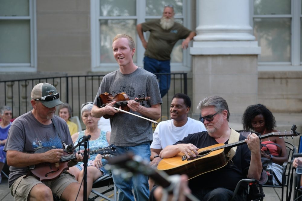 Musicians at the Bluegrass & Old-Time Jam Session on the square in Shelby, playing in front of the Earl Scruggs Center. Photo: Nancy Pierce.