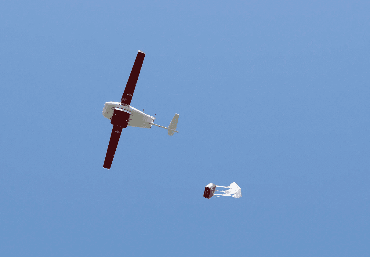 A drone dropping a package with a parachute