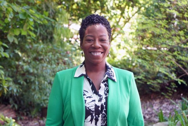 A photo of Toye Watson standing in the gardens at UNC Charlotte.